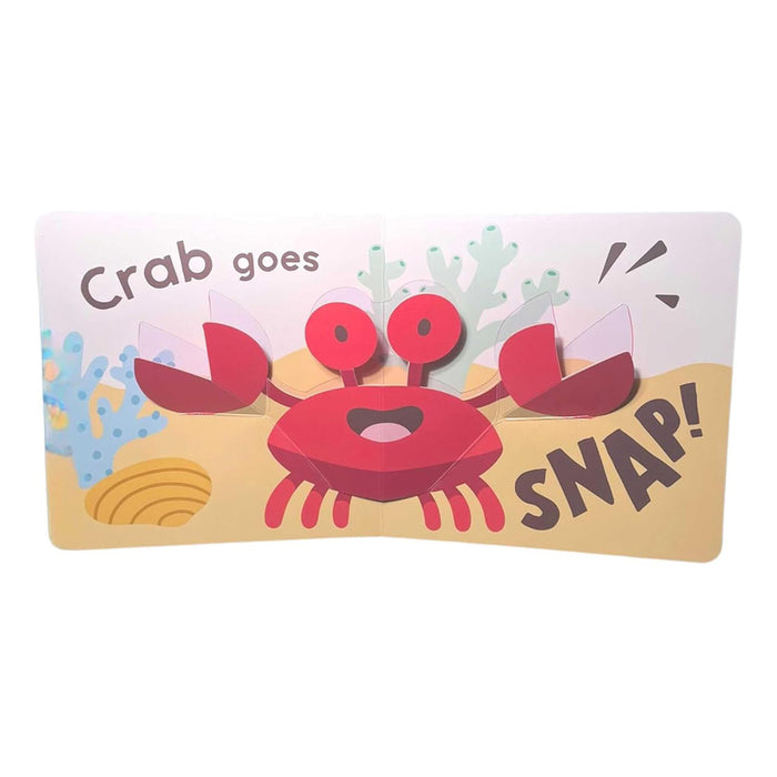 A page from Mini Pops: In the Sea!: Mini Pop-Up Board Book features a red crab with raised claws and big eyes, plus text reading, "Crab goes SNAP!"—with coral and sand details, ideal for toddler interactive or sea animal book collections.