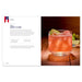 A pink cocktail garnished with lime wedges sits on wood. Featured in *Spirits of '76: Celebrating 250 Years with Cocktails from Every State*, the left page shows the drink’s name—Scarlett O’Hara—plus its ingredients and instructions.