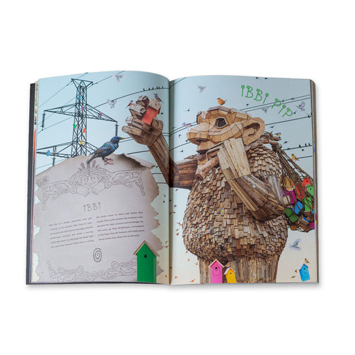 An open page of the Save The Humans – Catalogue displays an illustration of a large Thomas Dambo troll made of recycled materials, holding a birdhouse with smaller colorful ones hanging from its arms amid a landscape of birds and power lines.