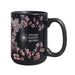 The Chicago Botanic Garden Cherry Blossom Mug is a black ceramic mug adorned with delicate pink cherry blossoms and “Chicago Botanic Garden” printed in white, alongside a floral logo. Elegant flowers are gracefully scattered around the mug, primarily on the left side and partially wrapping around for a sophisticated look.