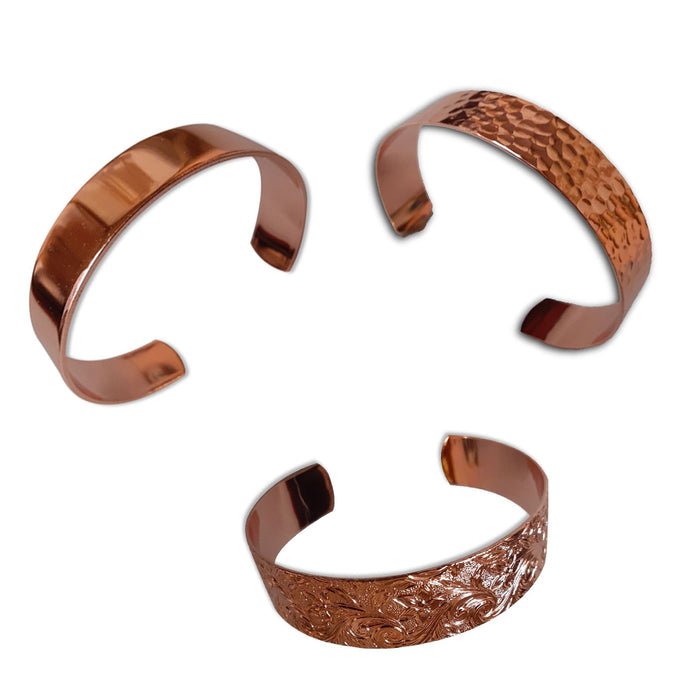 Three USSCM Reclaimed Copper Bracelets—one smooth, one hammered, and one intricately engraved—are hand-crafted in the USA from USS Constitution copper and feature open ends arranged in a triangle.