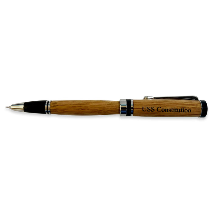 The Americana Pens and Pencils feature a USS Constitution design, crafted from wood with silver and black accents, engraved on the barrel, and include a removable cap that can be placed beside the tip.