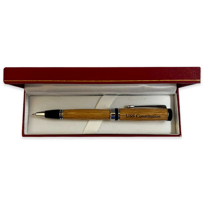 An Americana Pens and Pencils wood pen labeled USS Constitution is displayed in a red and white presentation box with a white interior, reflecting classic American style.