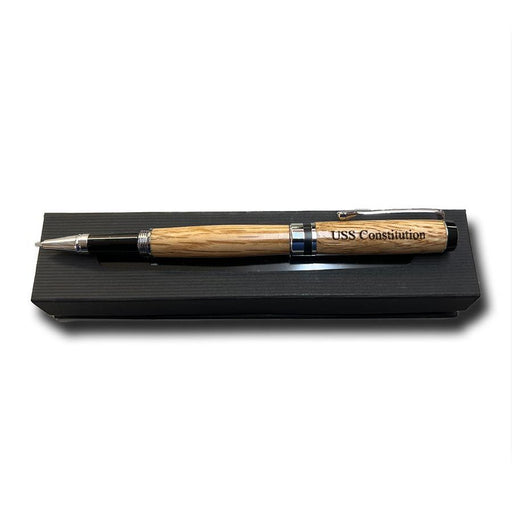 Introducing the Americana Pen—a handcrafted wood pen with a barrel engraved “USS Constitution,” this unique ballpoint rests elegantly in a black rectangular gift box.